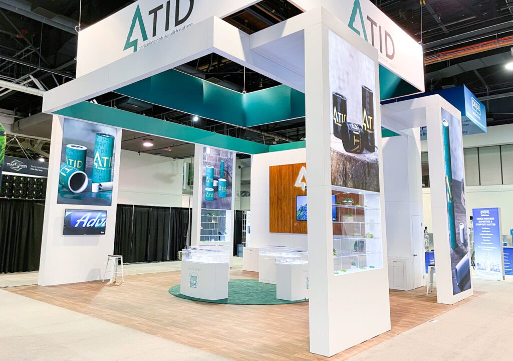 Modern ATID trade show booth with white towers and teal accents