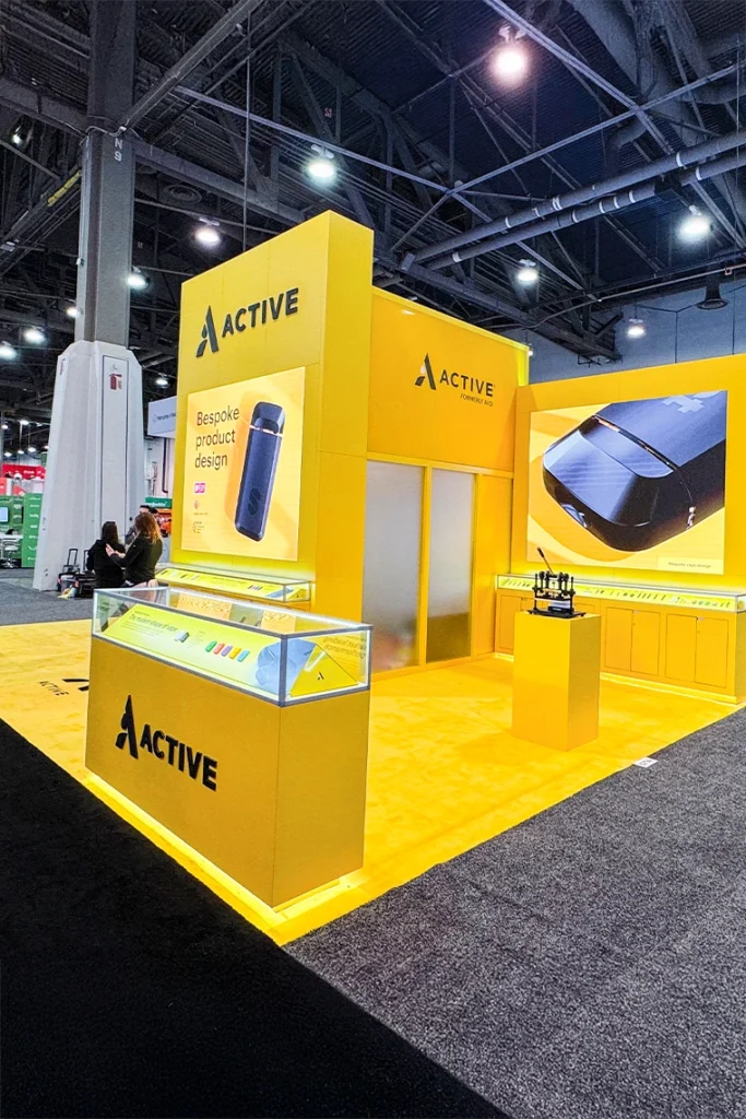 Bright yellow Active trade show booth showcasing branded technology products