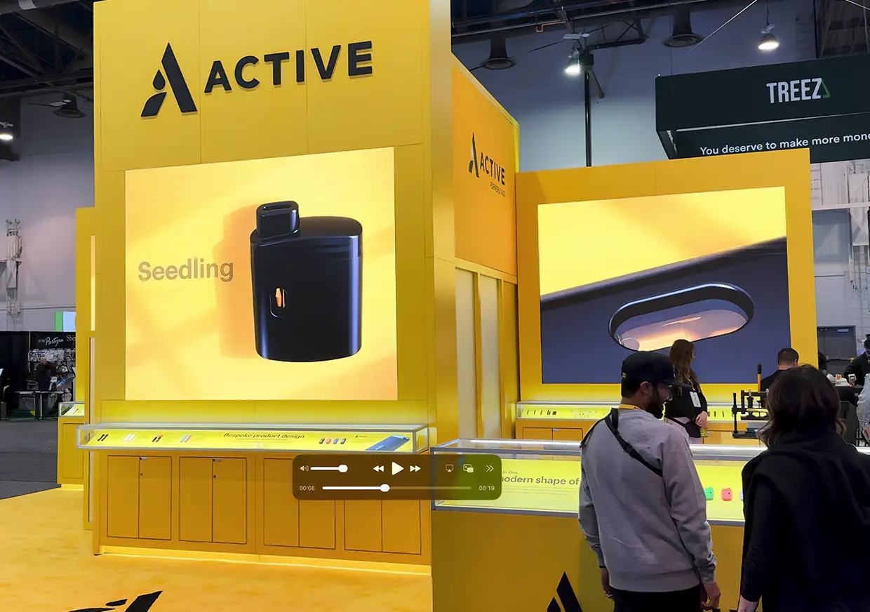 Visitors viewing product displays inside the bright yellow Active booth