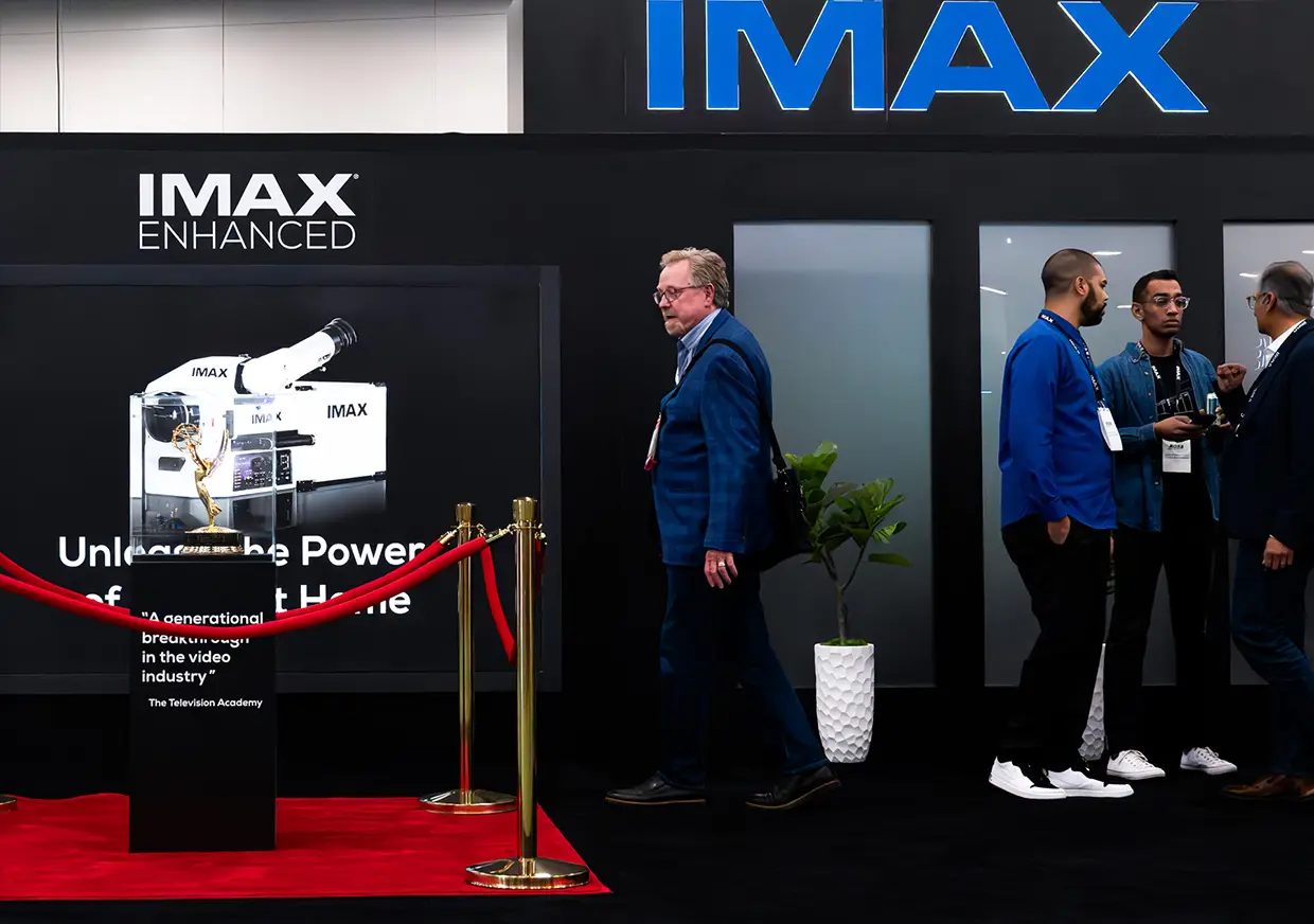 IMAX Enhanced booth featuring audio equipment display and visiting attendees