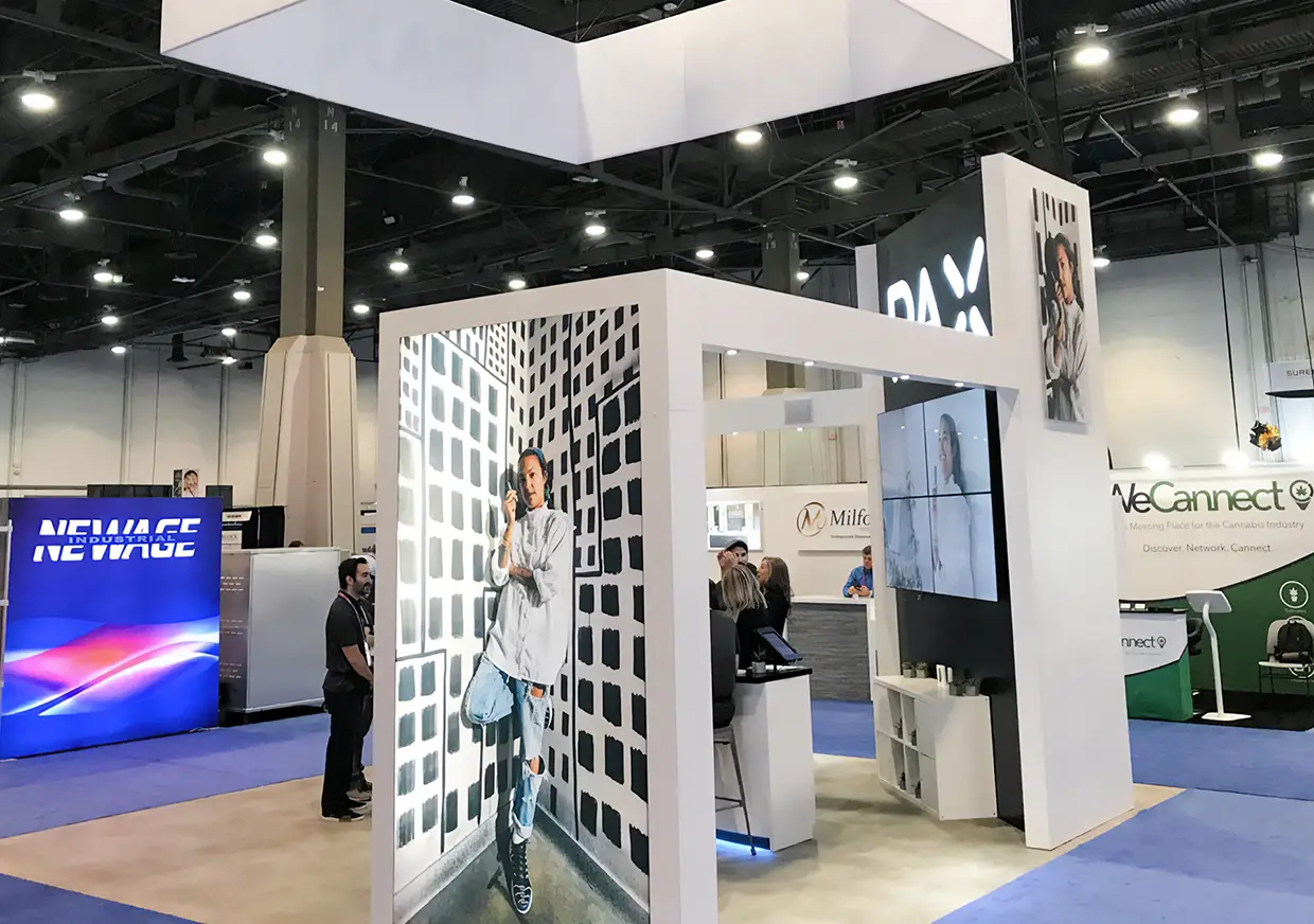Side view of PAX booth featuring white walls and product graphics