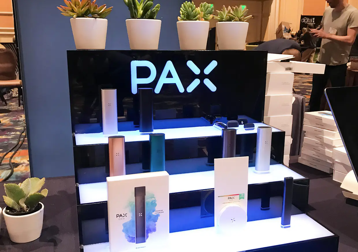 PAX branded product display featuring devices arranged on illuminated shelving